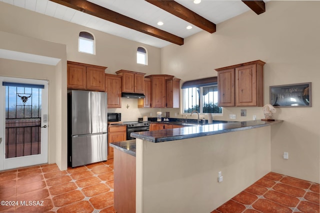 kitchen featuring a towering ceiling, electric range oven, stainless steel refrigerator, kitchen peninsula, and beam ceiling