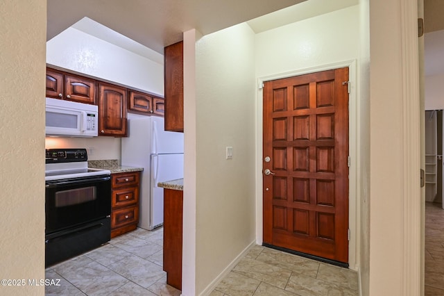 kitchen with white appliances, light stone countertops, and baseboards