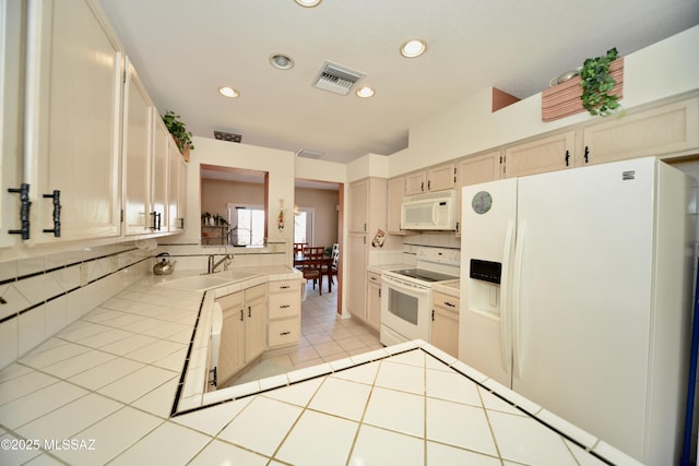 kitchen with white appliances, a sink, visible vents, and decorative backsplash