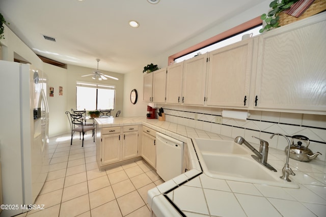 kitchen with tile countertops, light tile patterned floors, white appliances, a sink, and visible vents