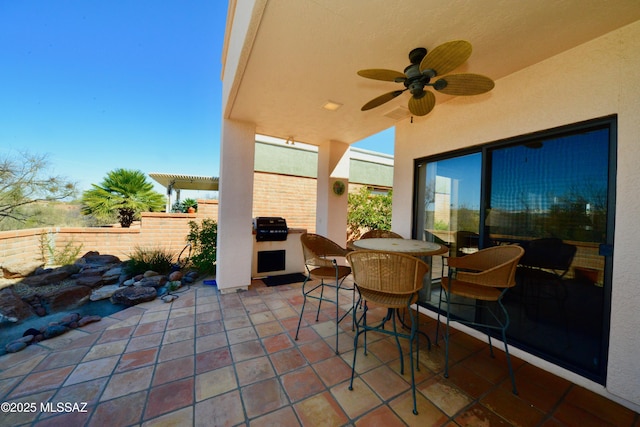 view of patio / terrace with ceiling fan, fence, an outdoor kitchen, and outdoor dining space