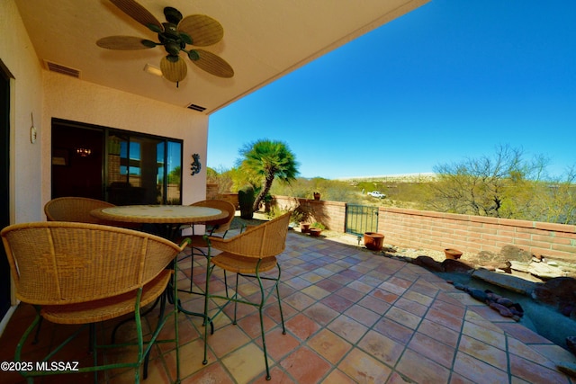 view of patio with ceiling fan, outdoor dining space, and visible vents