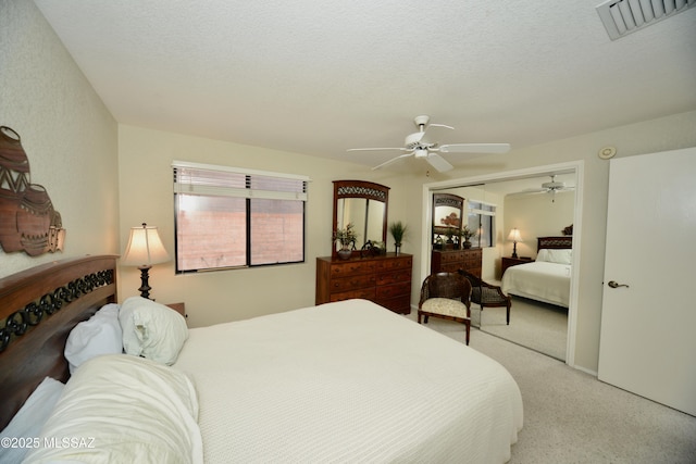 bedroom with a closet, visible vents, ceiling fan, and a textured ceiling