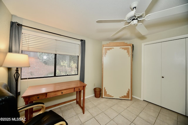 office space featuring light tile patterned floors, a ceiling fan, and baseboards