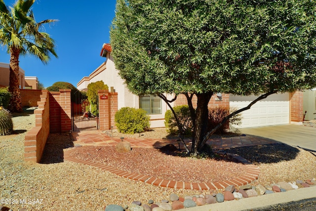 view of front facade featuring concrete driveway, brick siding, an attached garage, and a gate