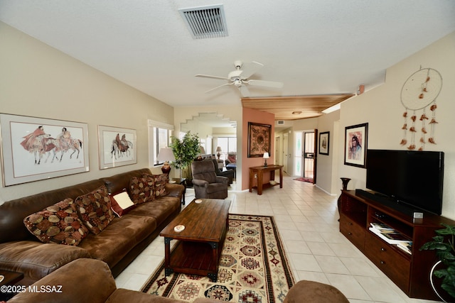 living area featuring light tile patterned floors, visible vents, and a ceiling fan