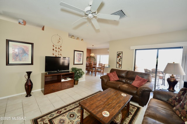 living area featuring ceiling fan, light tile patterned flooring, visible vents, and baseboards