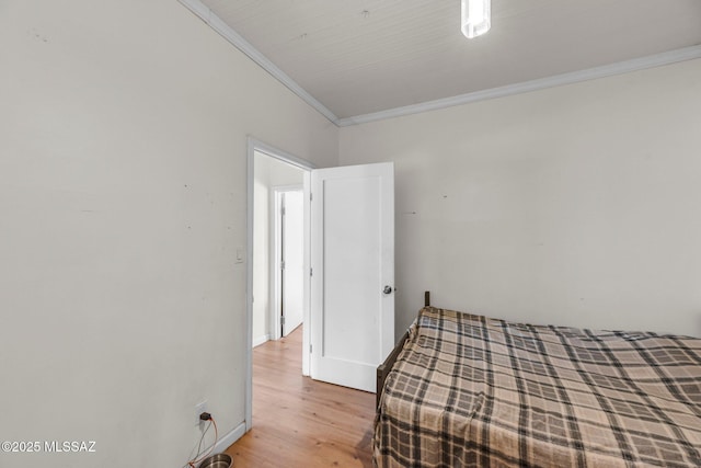 bedroom featuring crown molding and wood-type flooring