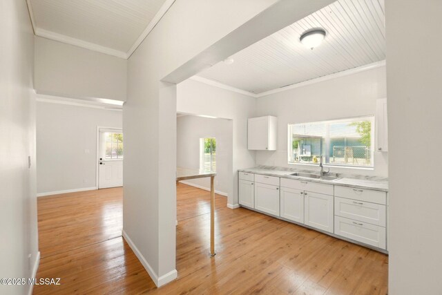 816 W 11th St, Safford, AZ 85546 - kitchen featuring a sink, crown molding, light wood-style floors, white cabinetry, and light countertops