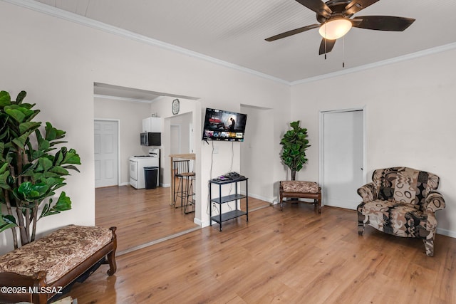 sitting room featuring ceiling fan, ornamental molding, washer / dryer, and hardwood / wood-style floors