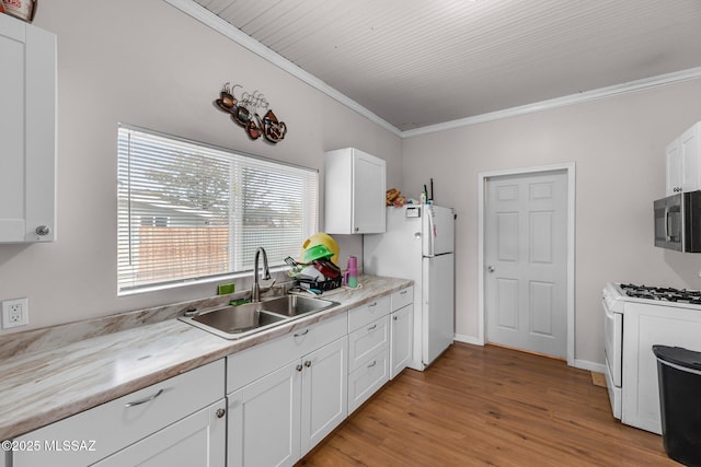 kitchen with crown molding, sink, white cabinets, and white appliances