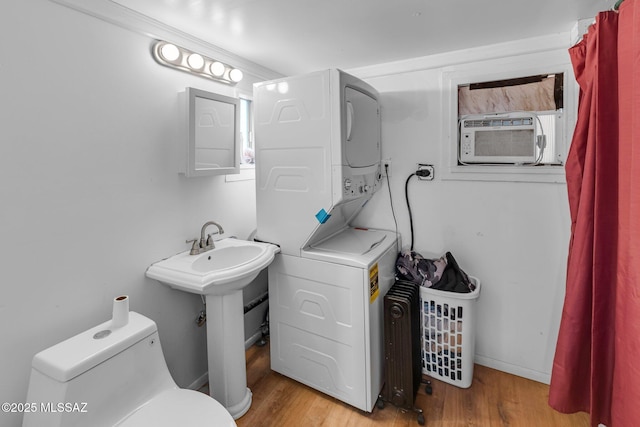 bathroom with toilet, wood-type flooring, stacked washing maching and dryer, and cooling unit