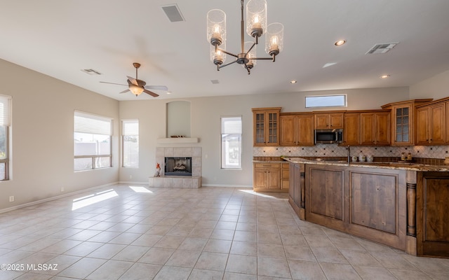 kitchen featuring light tile patterned flooring, backsplash, and light stone counters