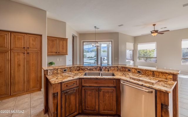 kitchen featuring dishwasher, light stone countertops, pendant lighting, ceiling fan with notable chandelier, and sink