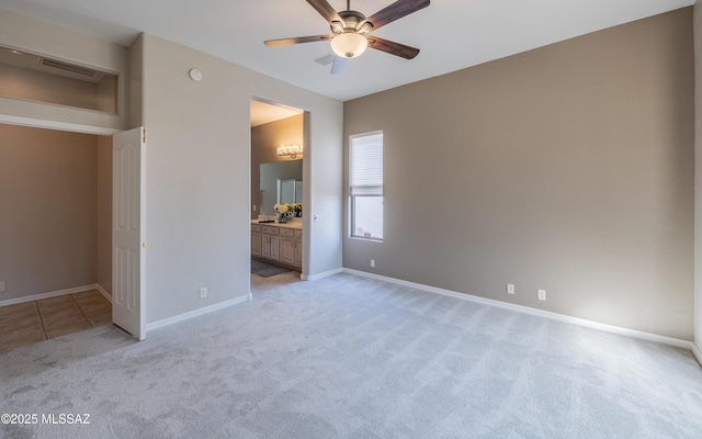 unfurnished bedroom with light carpet, ensuite bathroom, and ceiling fan