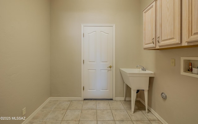 washroom with light tile patterned floors, washer hookup, and cabinets