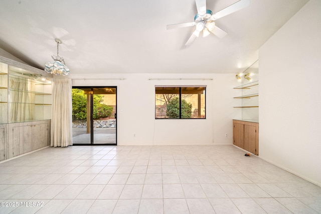 spare room featuring ceiling fan, lofted ceiling, and light tile patterned floors