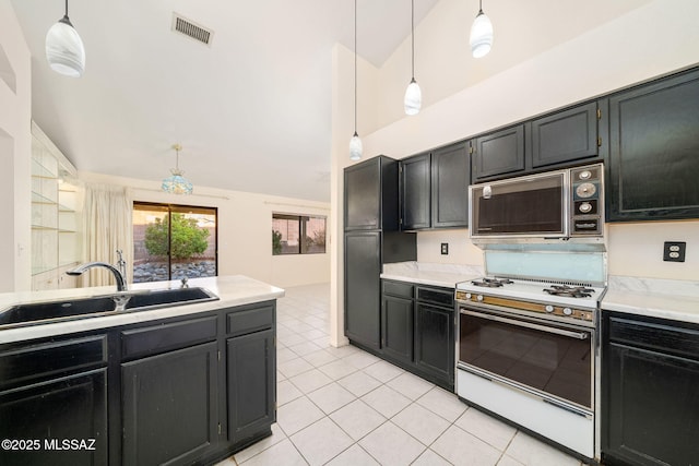 kitchen with white range with gas cooktop, sink, pendant lighting, and light tile patterned floors