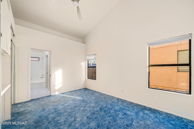 unfurnished bedroom with connected bathroom, high vaulted ceiling, and carpet flooring