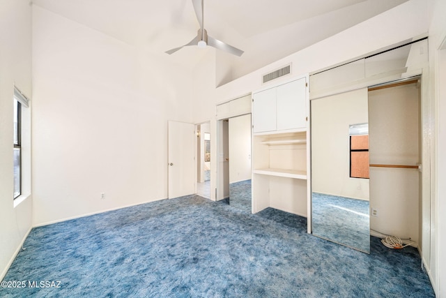 unfurnished bedroom featuring dark colored carpet, ceiling fan, and high vaulted ceiling