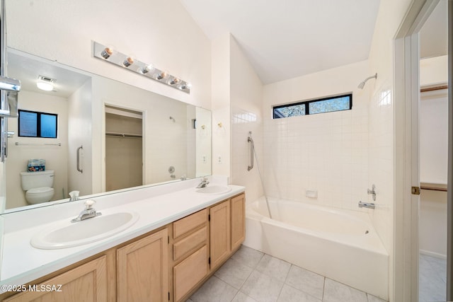 bathroom featuring tile patterned floors, toilet, vaulted ceiling, and vanity