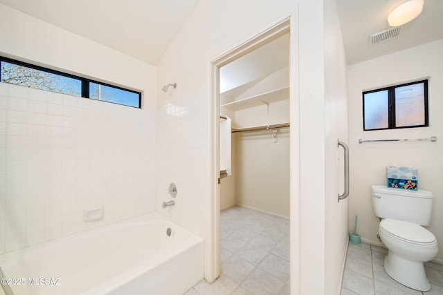 bathroom with tile patterned flooring, bathtub / shower combination, and toilet