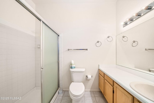 bathroom with tile patterned flooring, vanity, a shower with shower door, and toilet