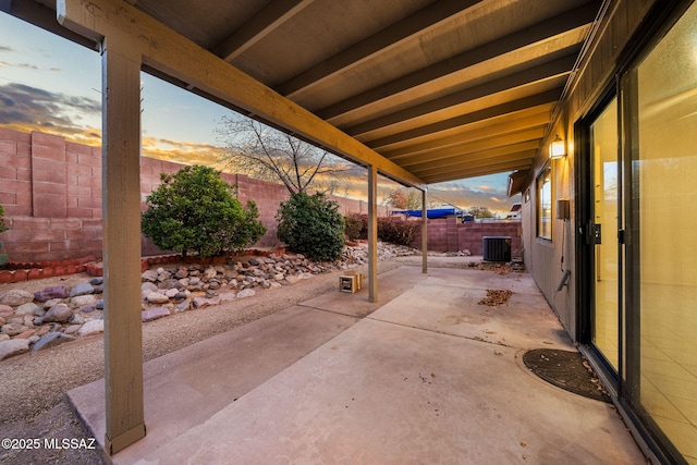 patio terrace at dusk featuring central AC