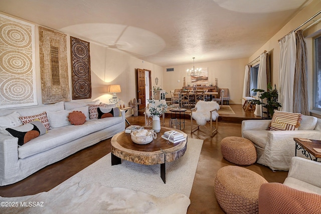 living room with a chandelier and concrete floors