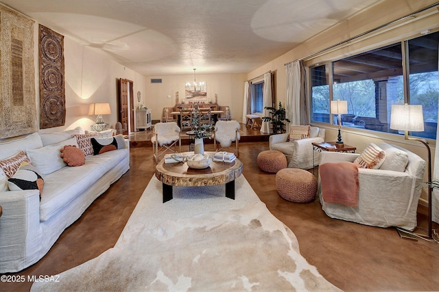 living room with a notable chandelier and concrete floors