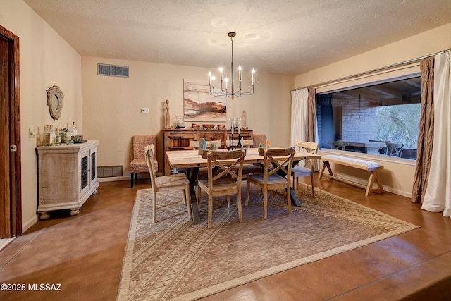 dining space featuring a textured ceiling and a notable chandelier