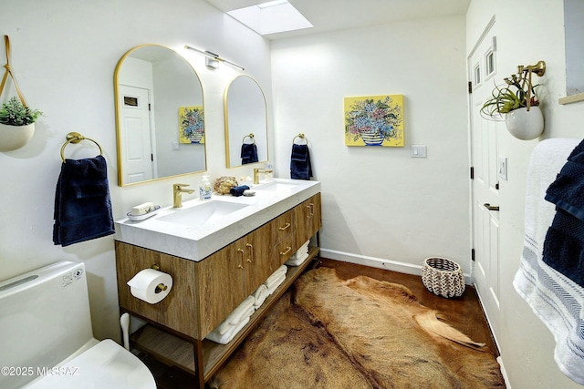 bathroom featuring vanity, toilet, and a skylight