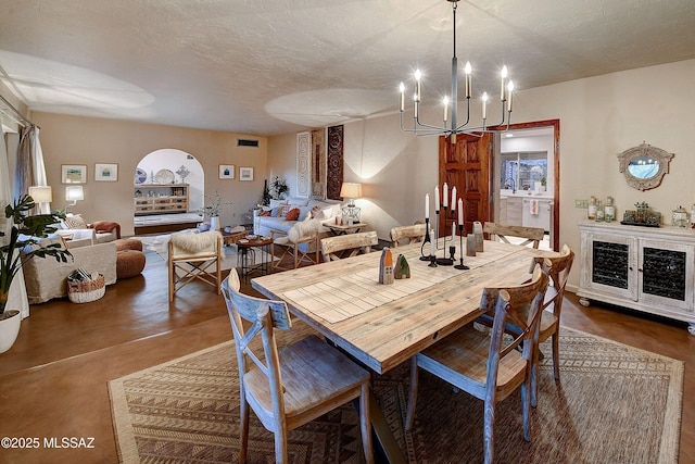 dining room featuring concrete flooring, an inviting chandelier, and a textured ceiling