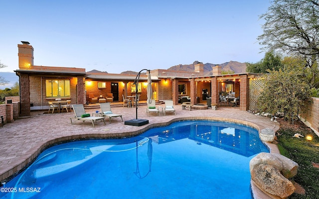 pool at dusk featuring a patio