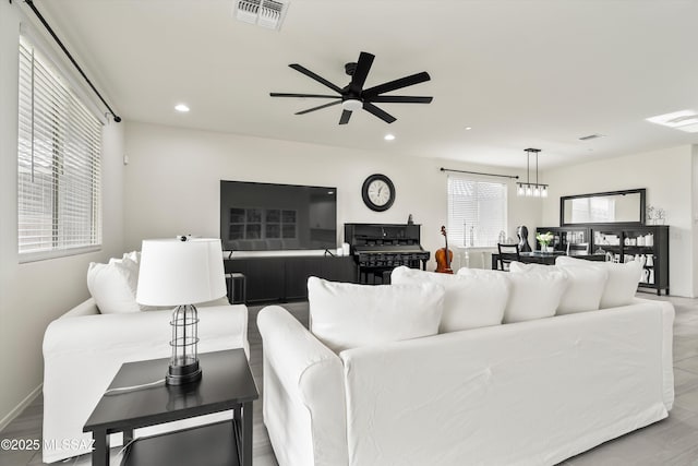 living room featuring recessed lighting, visible vents, and ceiling fan