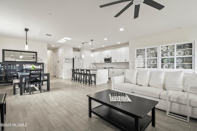 living area with recessed lighting, visible vents, and ceiling fan