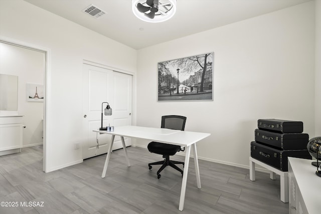 office space featuring baseboards and visible vents