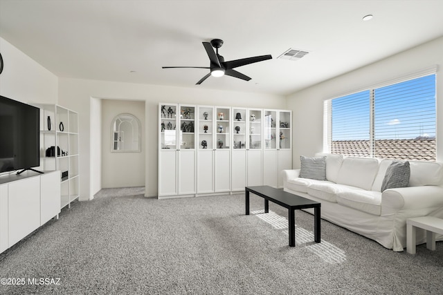 living room with light carpet, ceiling fan, and visible vents