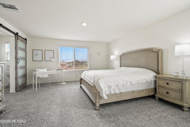 carpeted bedroom with visible vents and a barn door