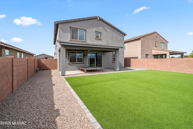 rear view of property with a lawn, a patio area, a fenced backyard, and stucco siding