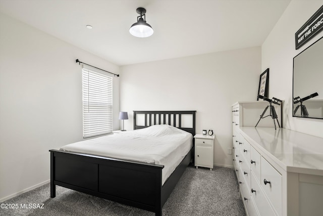 bedroom featuring dark carpet and baseboards