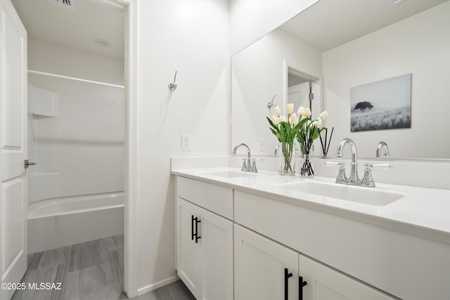 bathroom with double vanity, shower / bath combination, and a sink