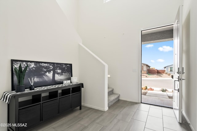 entrance foyer featuring stairway and baseboards