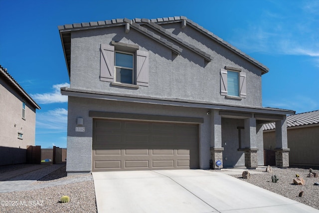 view of front of property with concrete driveway, a tiled roof, an attached garage, and stucco siding