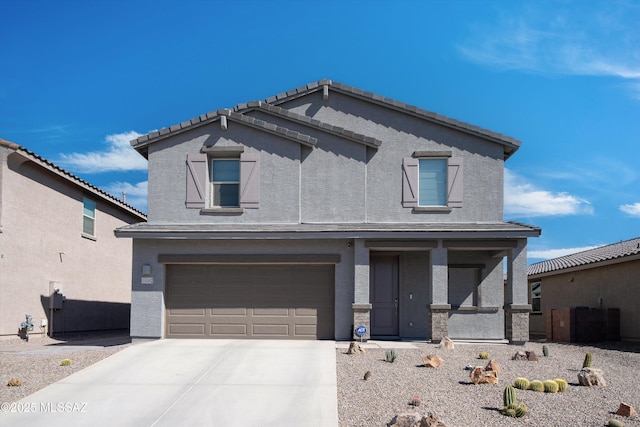 view of front facade with a garage, concrete driveway, a tiled roof, and stucco siding