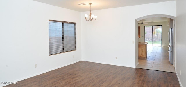 unfurnished room with ceiling fan with notable chandelier and dark hardwood / wood-style floors