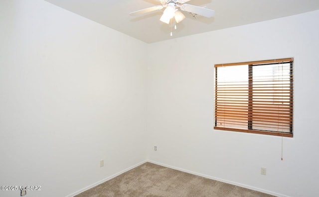 spare room with ceiling fan and light carpet