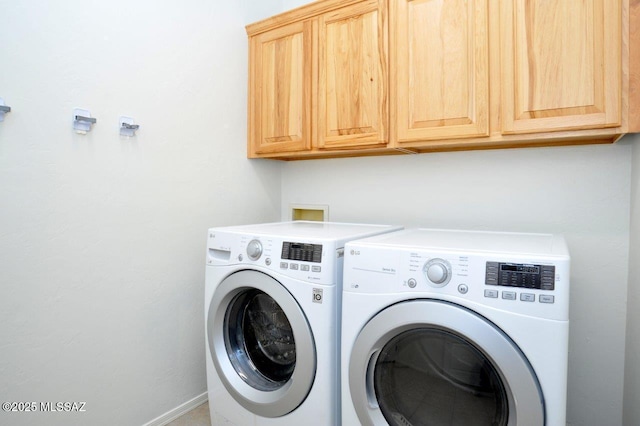 laundry room featuring washing machine and dryer and cabinets