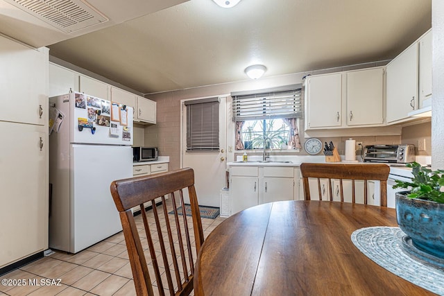 dining space featuring sink and light tile patterned floors