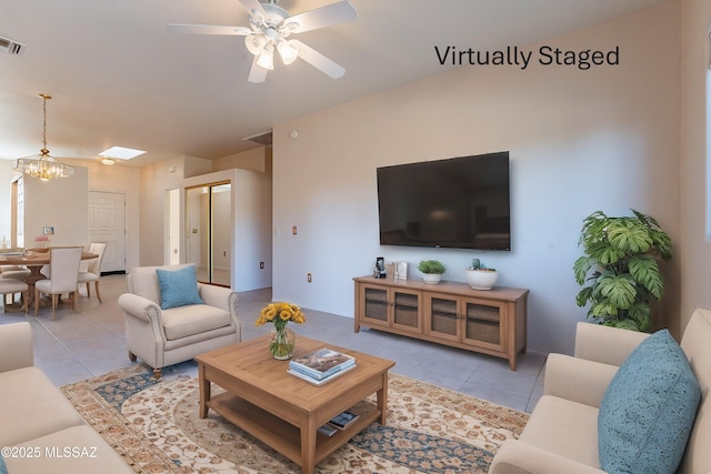 tiled living room featuring visible vents and ceiling fan with notable chandelier